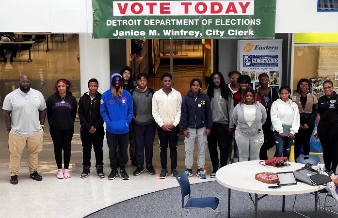 high school students standing under a Vote Today banner